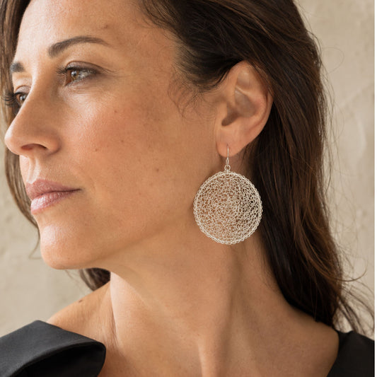 Model wearing large hand-crocheted Crochet Moon sterling silver earrings by JYOCO
