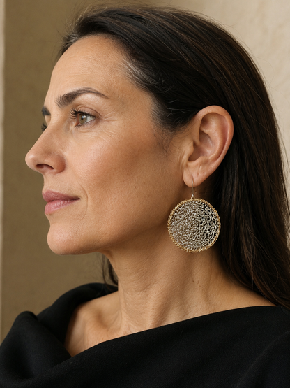 Model wearing Crochet Eclipse hand-crocheted sterling silver earrings on brass hoops by JYOCO