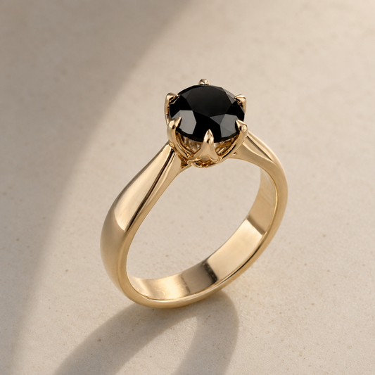 Gold ring with a black gemstone on a beige background