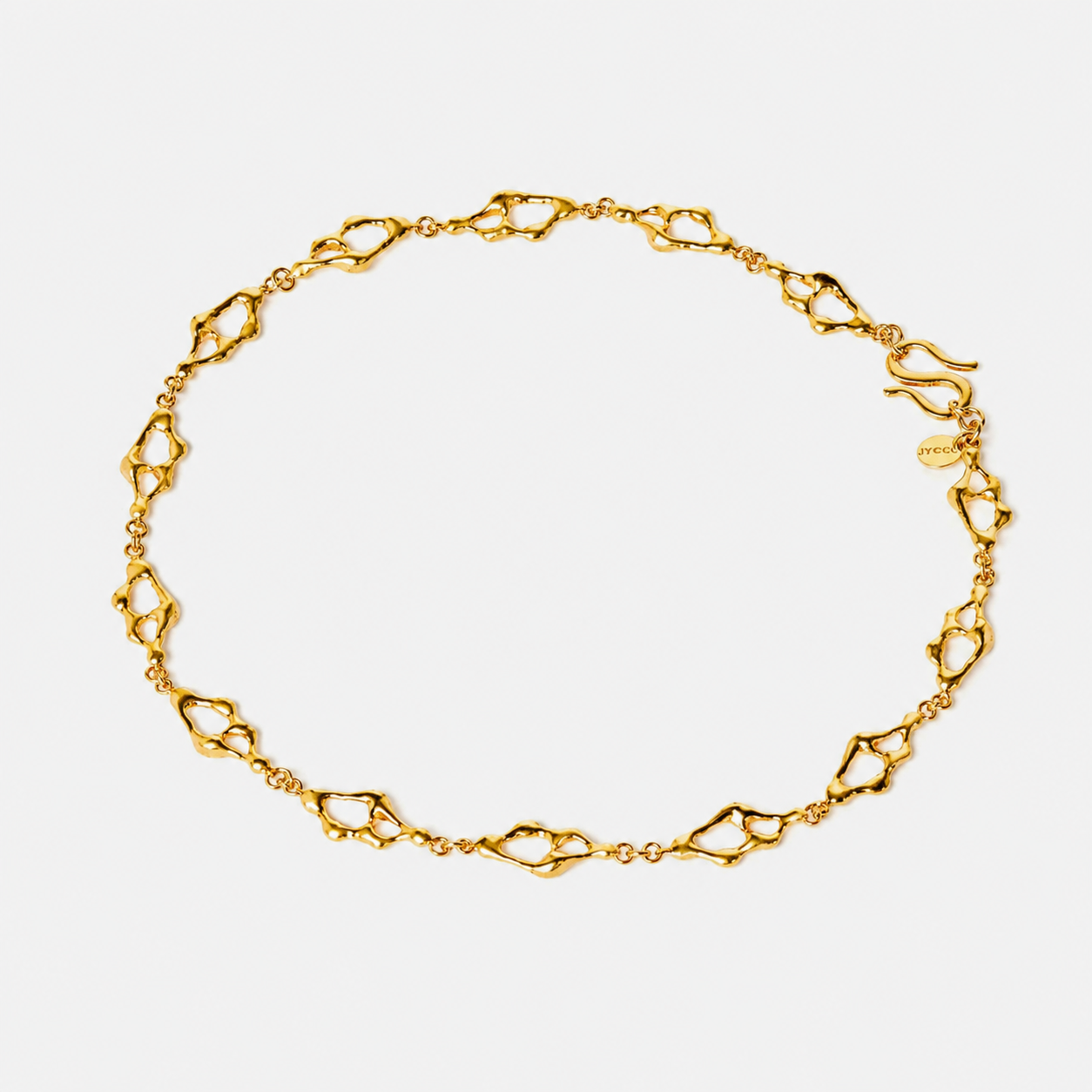 Sculptural gold necklace with organic openwork links arranged in a flowing circular composition