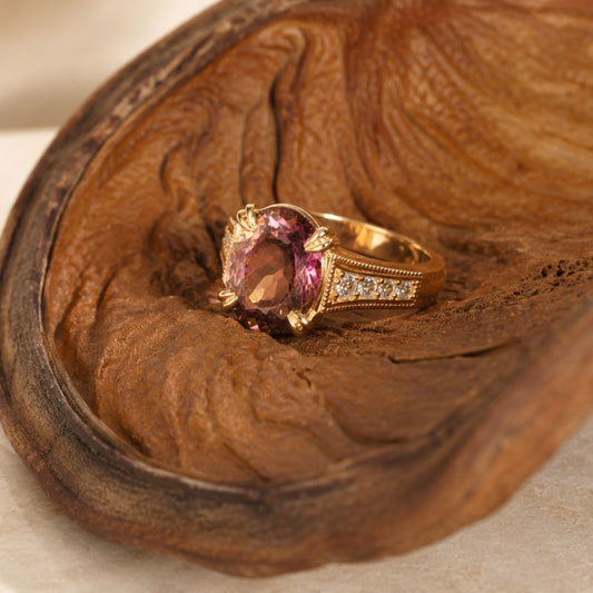 Gold ring with a purple gemstone on a wooden surface