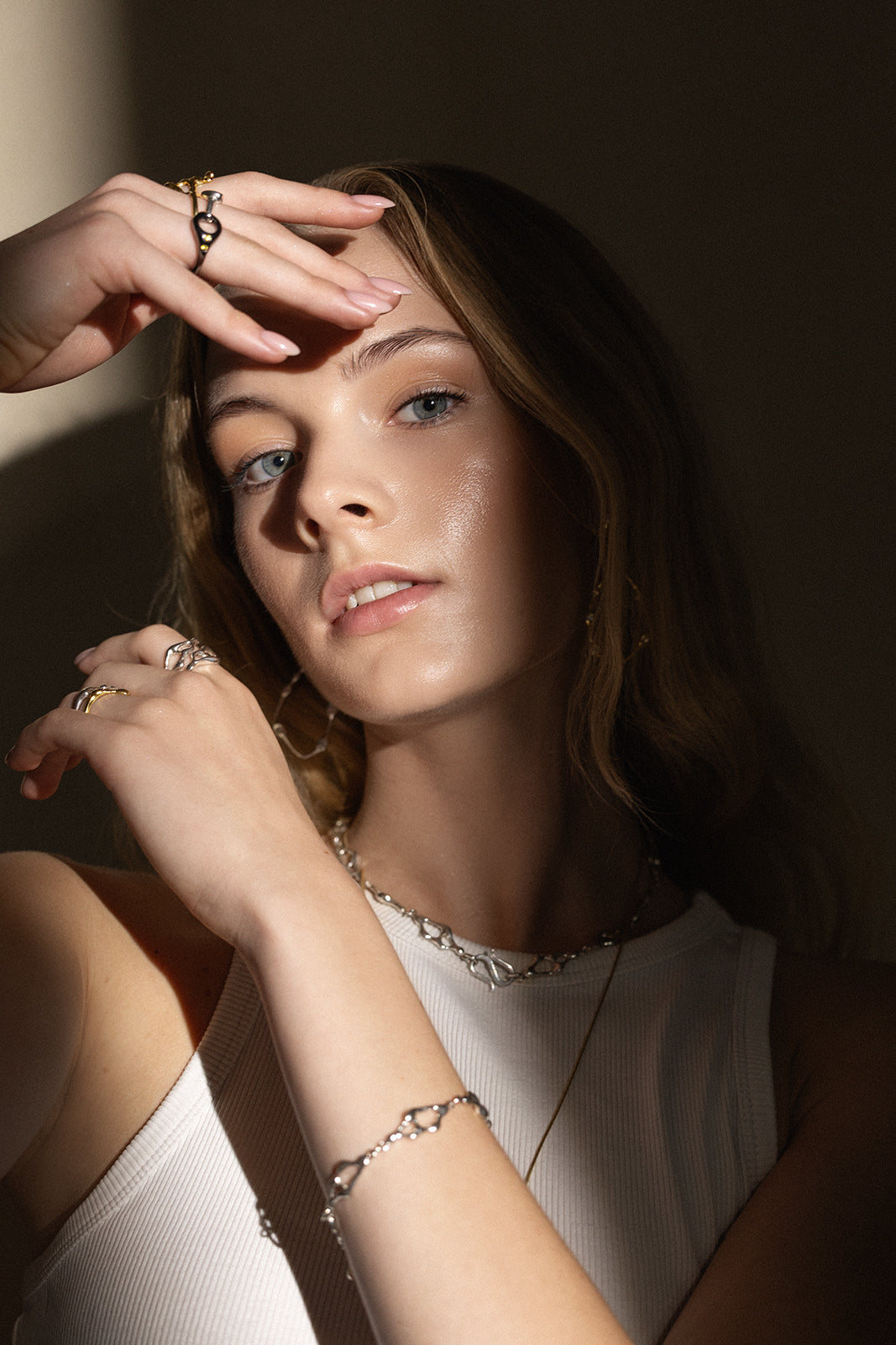 Woman on a dark backround wearing JYOCO jewellery from Drop collection