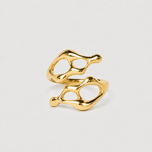 Gold ring with a unique, organic design on a light gray background