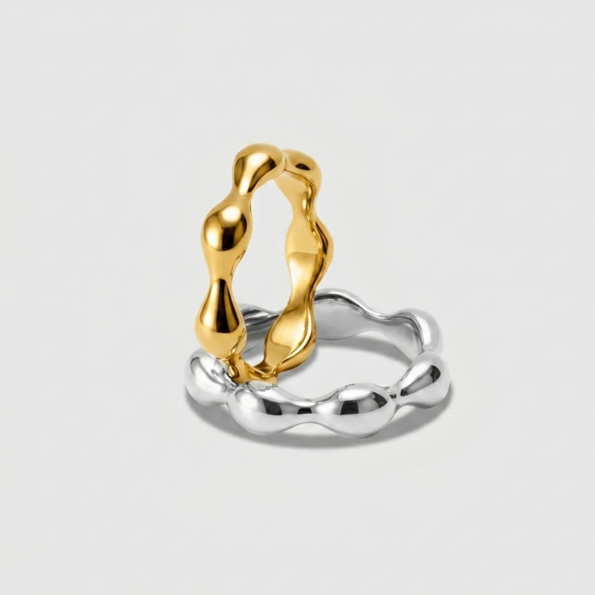 Gold and silver ring on a light gray background