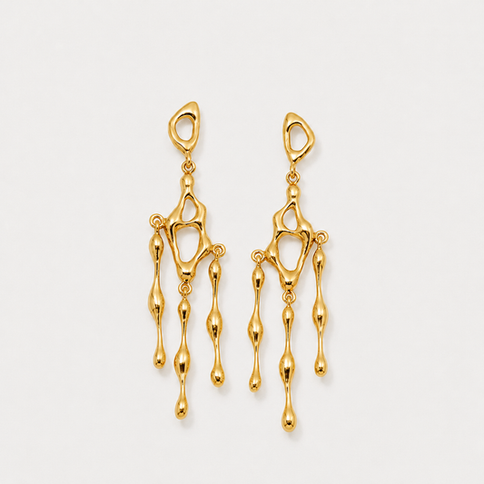 Gold earrings on a light gray background
