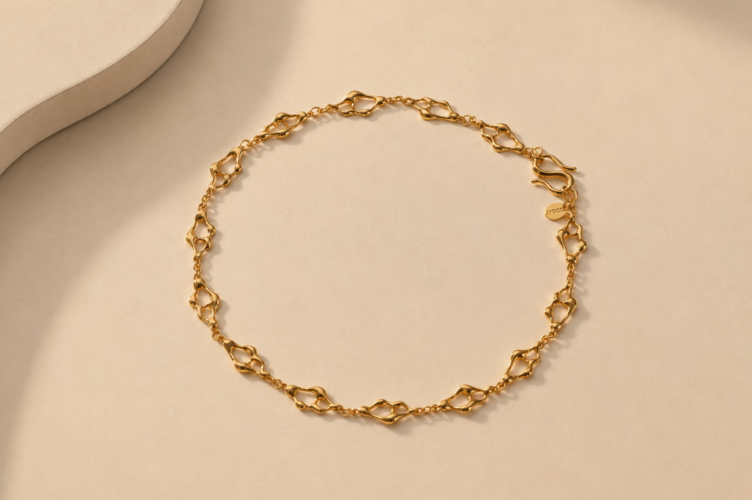 Gold chain bracelet on a beige background
