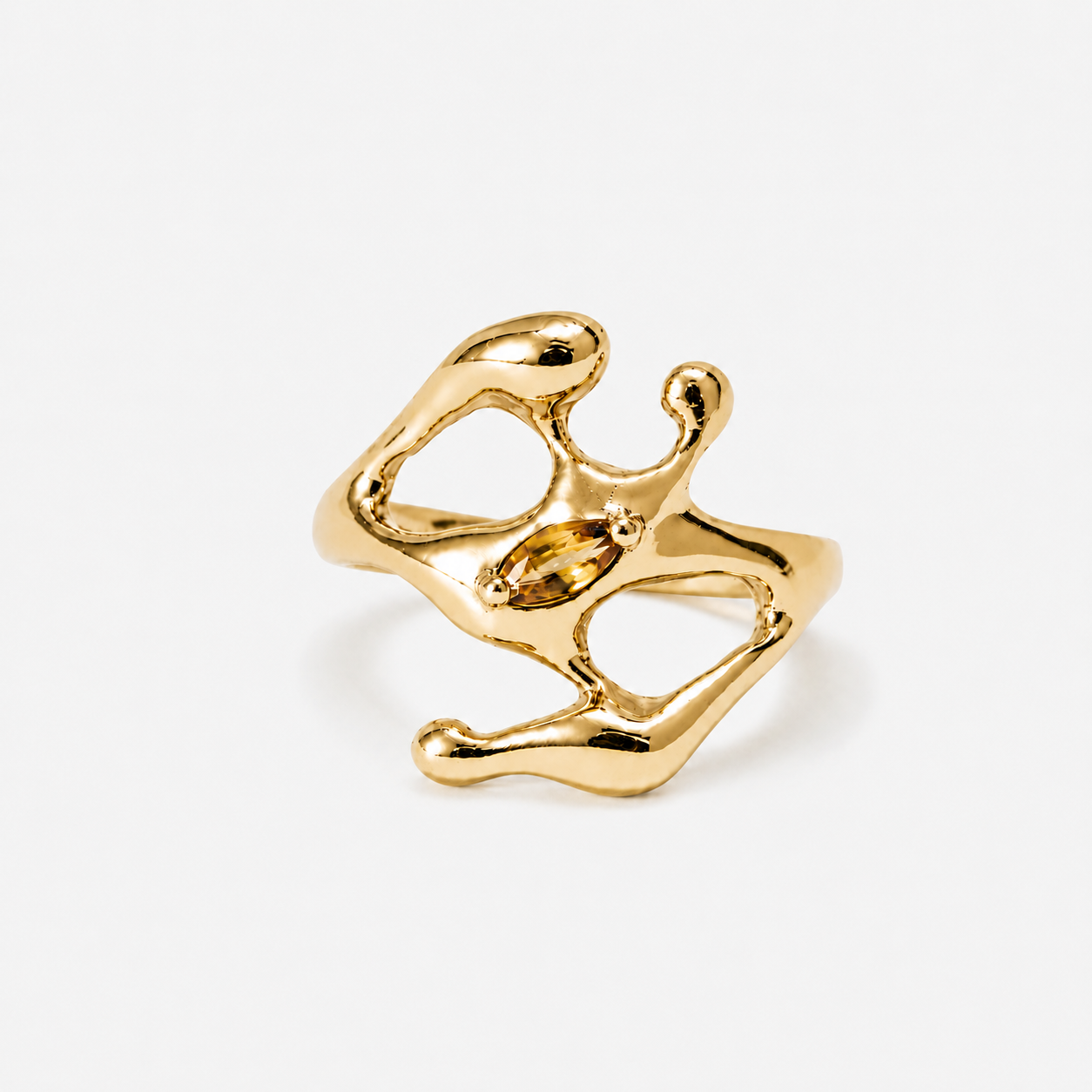 Gold ring with a yellow gemstone on a white background
