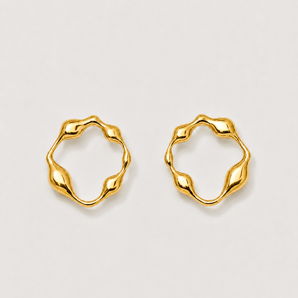 Pair of gold hoop earrings on a light gray background