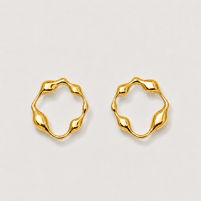 Pair of gold hoop earrings on a light gray background