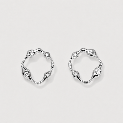 Pair of silver hoop earrings with small crystals on a light gray background