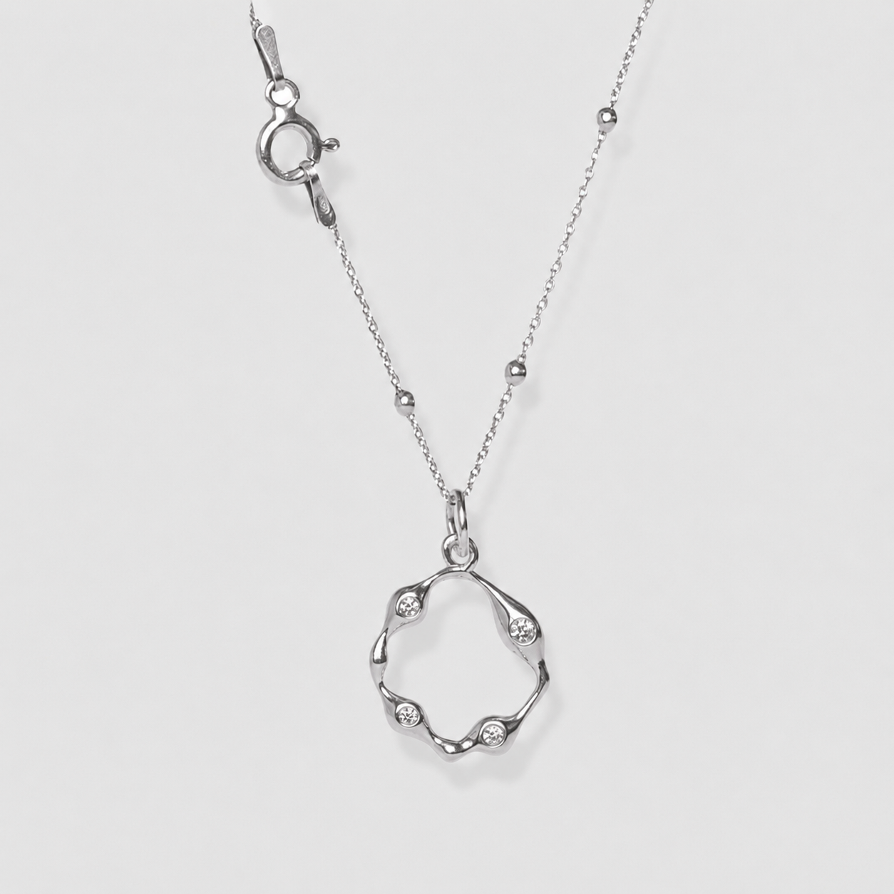 Silver necklace with a unique pendant on a light gray background