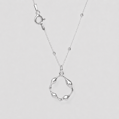 Silver necklace with a unique pendant on a light gray background